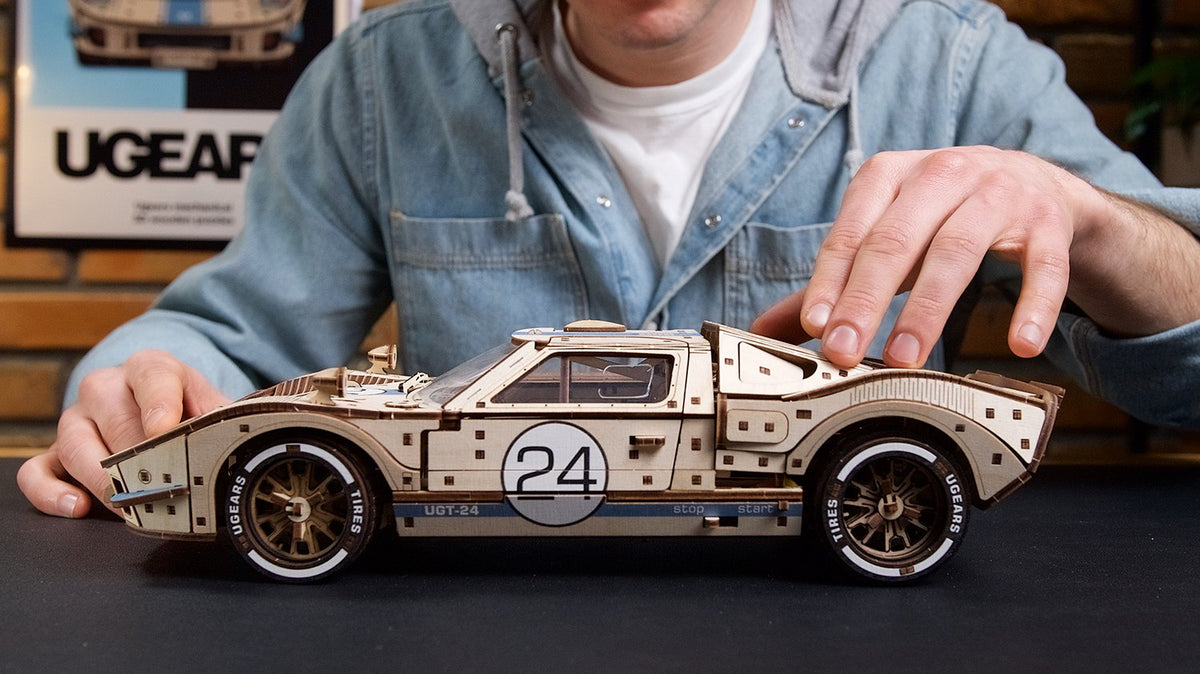 Hände am fertig gebauten Rennwagen UGT-24 aus Holz