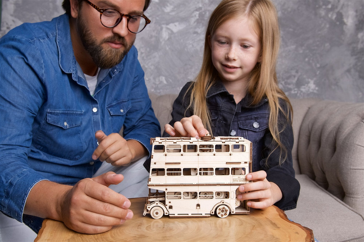 Erwachsener und Kind mit dem fertig gebauten Fahrenden Ritter aus Holz