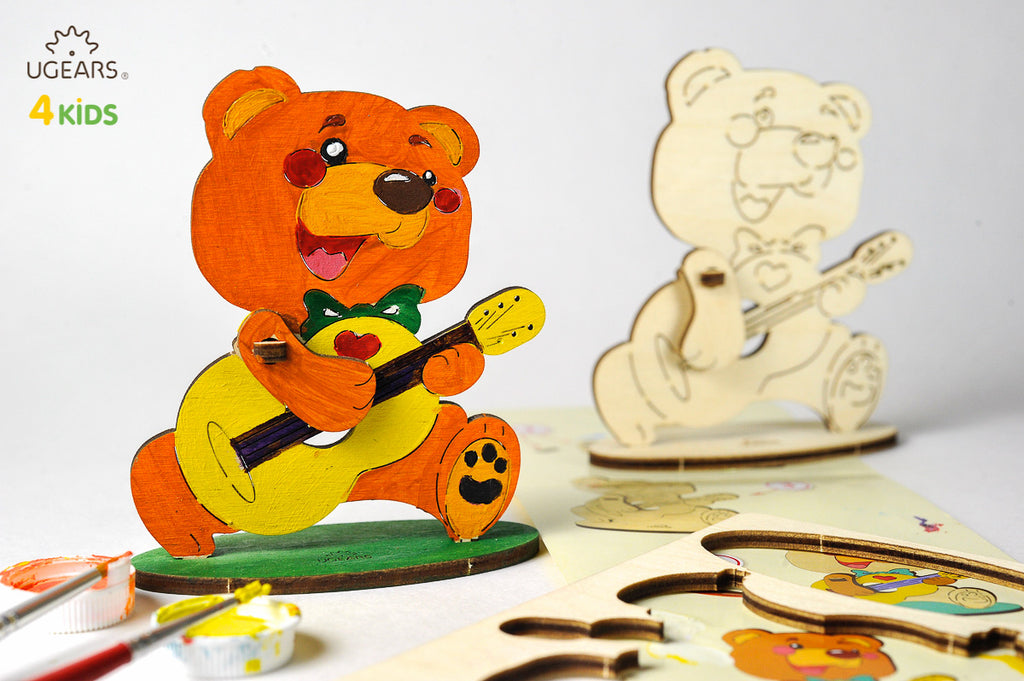 Bär mit Gitarre aus Holz, bemalt und unbemalt nebeneinander