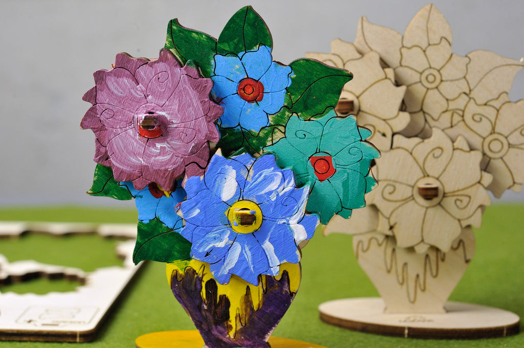 Blumenstrauß aus Holz, bunt bemalt neben unbemalter Version