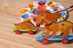 Hund und Katze aus Holz auf Rollbrettern, bunt bemalt