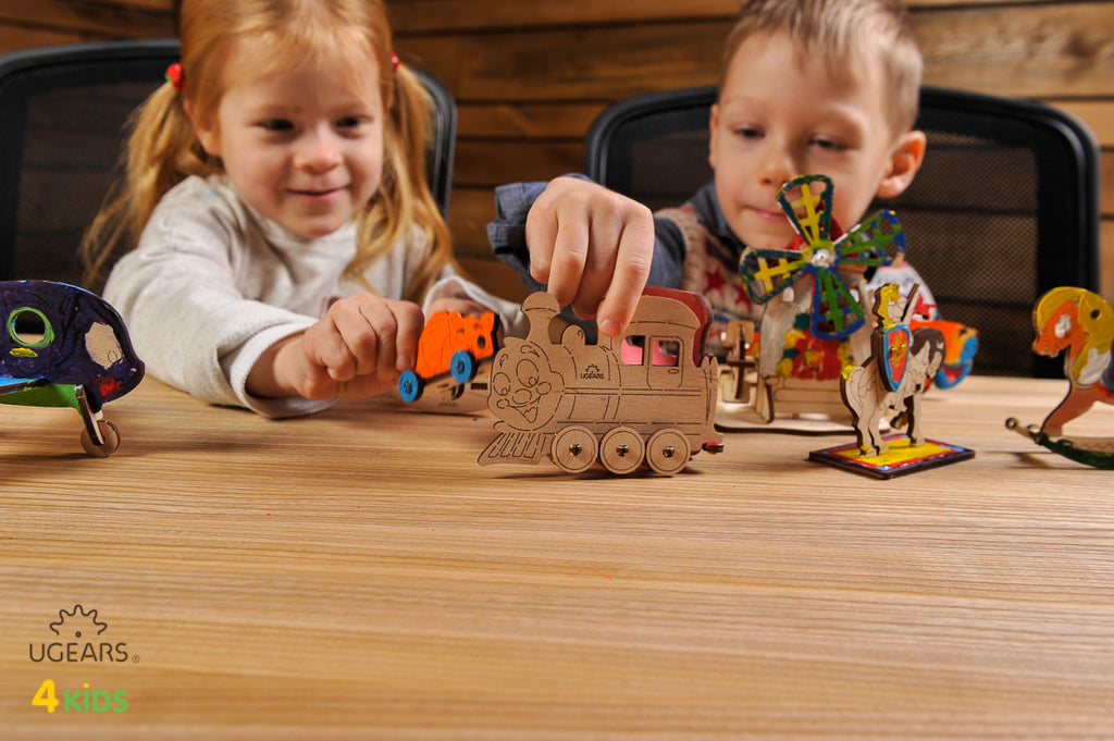 Zwei Kinder spielen am Tisch mit bemalten Holzfiguren